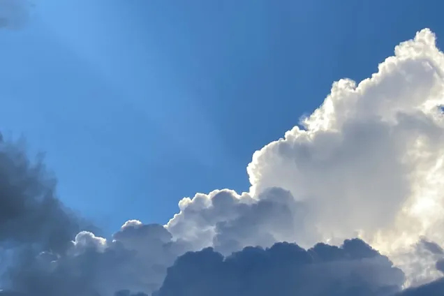 Blå himmel med vita och grå moln. Foto.